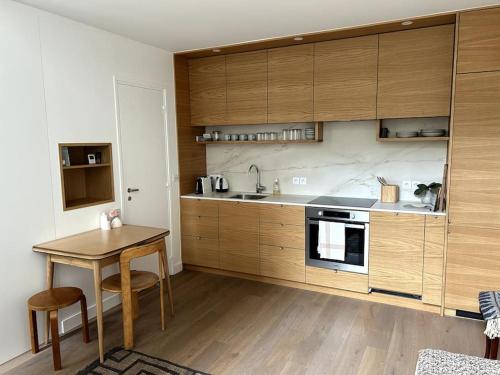 une cuisine avec des armoires en bois et une table en bois dans l'établissement Elegant loft-duplex pour 2/3 personnes, à Paris