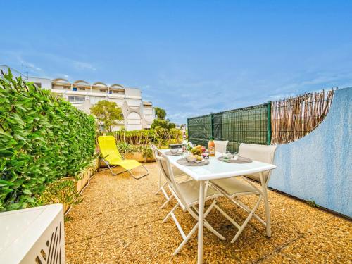 une table blanche et des chaises sur un balcon dans l'établissement Studio Les Floralies II-13 by Interhome, au Grau-du-Roi