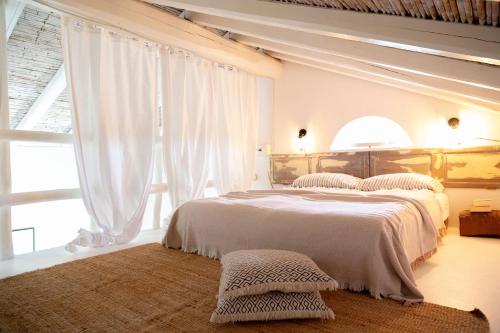 a bedroom with two beds and a large window at CASA MANORGAI DUE in Orosei