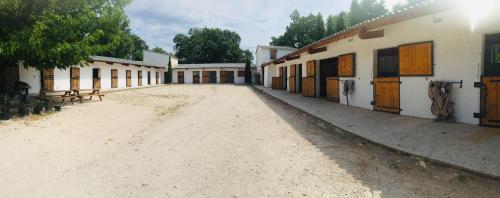 a group of buildings with a dirt road between them at Appartement à la campagne in LʼIsle-sur-la-Sorgue