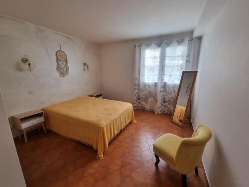 une chambre avec un lit, une chaise et une fenêtre dans l'établissement T2 en rez de villa, à Sanary-sur-Mer