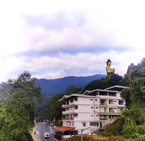 a woman sitting on top of a building at The Alnus Ravangla in Ravangla