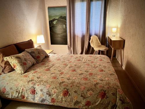 a bedroom with a bed and a desk and a window at La Croisée des Chemins 