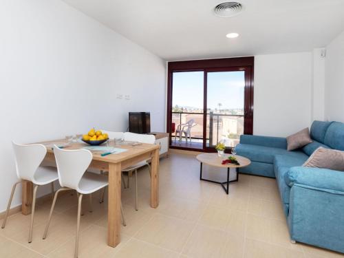 Una sala de estar con una mesa y un sofá azul. en Apartment Barco 3 by Interhome, en Vinarós
