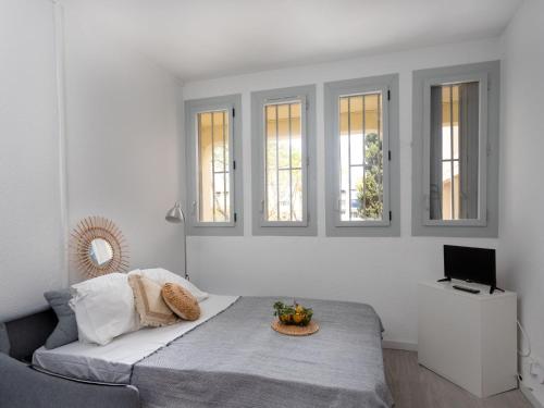 une chambre blanche avec un lit et une télévision dans l'établissement Studio les Cheops by Interhome, à La Grande Motte