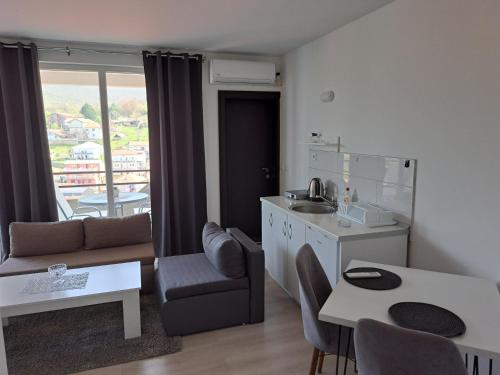 eine Küche und ein Wohnzimmer mit einem Tisch und einem Sofa in der Unterkunft Apartments Marko in Ohrid