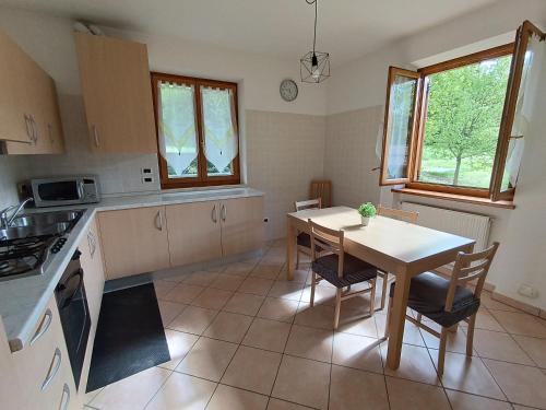 a kitchen with a table and a table and chairs at Villa Irma in Levico Terme