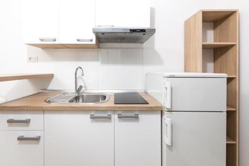 a white kitchen with a sink and a refrigerator at Stella Mare Eco Boutique House in Zavala