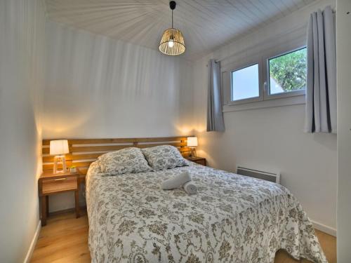 - une chambre avec un lit avec une couette blanche et 2 fenêtres dans l'établissement Holiday Home Les Cariatides by Interhome, à Saint-Pierre-dʼOléron
