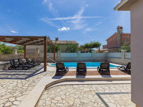 een zwembad met ligstoelen voor een huis bij Villa Dzana by Interhome in Mednjan