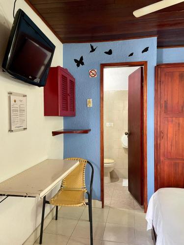 a room with a table and a tv on the wall at Hotel Nueva Granada in Santa Marta