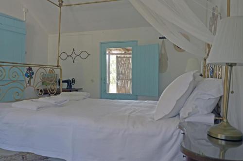 a bedroom with a white bed and a window at Casa da Horta in Carvalhal