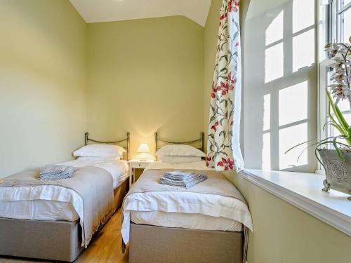 2 camas individuales en una habitación con ventana en 2 Bed in Jedburgh 86021, en Hawick