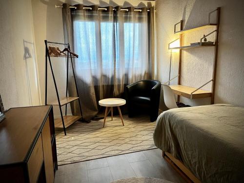 1 dormitorio con cama, escritorio y silla en La Croisée des Chemins, 