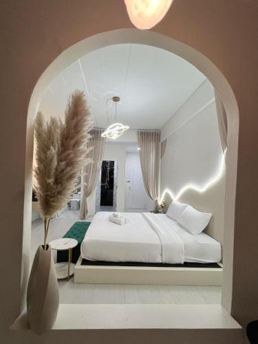 24Rooms นครสวรรค์ في ناخون صوان: غرفة نوم بسرير ابيض و مزهرية بها نبات