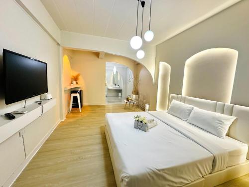 sypialnia z dużym białym łóżkiem i telewizorem z płaskim ekranem w obiekcie 24Rooms นครสวรรค์ w mieście Nakhon Sawan