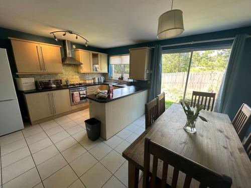 a kitchen and dining room with a wooden table and chairs at Stunning semi-detached townhouse, Holywood, Sleeps 6 - 10 mins from Belfast in Belfast