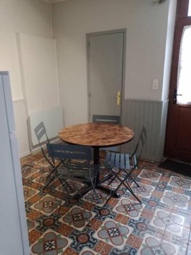 une table et des chaises dans une pièce avec un tapis dans l'établissement appartement centre village, à Cerdon
