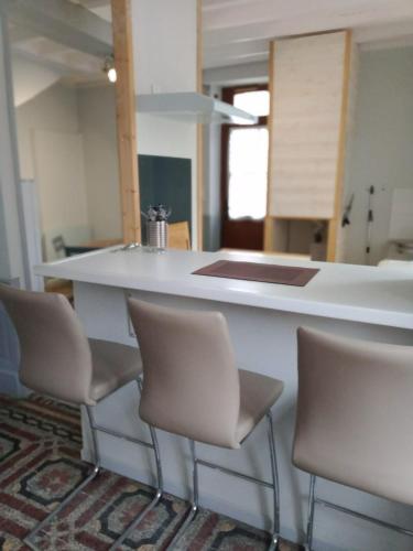 une cuisine avec un comptoir et 4 chaises autour de celle-ci dans l'établissement appartement centre village, à Cerdon