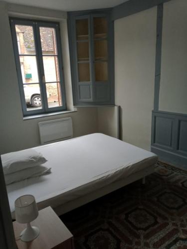 une chambre avec un grand lit blanc avec une fenêtre dans l'établissement appartement centre village, à Cerdon