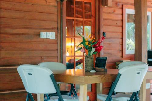 a table with chairs and a vase of flowers on it at TropicalArts Resort&Studios in Bocas del Toro