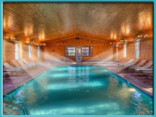 a large swimming pool in a building with chairs at Stroudsmoor Country Inn in Stroudsburg