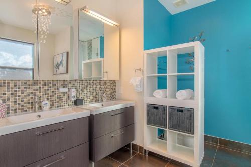 La salle de bains est pourvue de 2 lavabos et d'un grand miroir. dans l'établissement Dream House 5 Bedroom w Amazing Heated POOL, à Hollywood