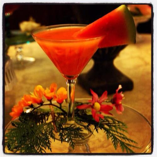 a drink in a martini glass on a table with flowers at Stroudsmoor Country Inn in Stroudsburg