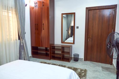 a bedroom with a mirror and a bed and a dresser at Lush Meadows Apartments in Kadobunkuro