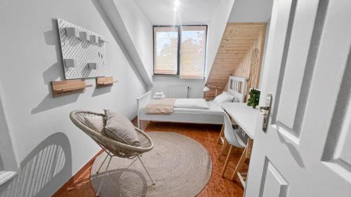 een kleine kamer met een stoel en een bed bij Flatista Homes - Penthouse with Rooftop Gym in München