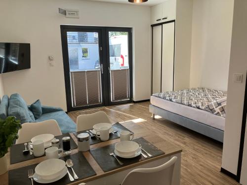 ein Wohnzimmer mit einem Bett und einem Tisch und Stühlen in der Unterkunft AGAT Pokoje Gościnne Apartamenty in Pobierowo