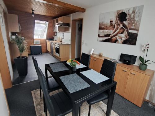 Una cocina y un comedor con una mesa y sillas negras. en Cosy Retreat in Friolzheim, en Friolzheim