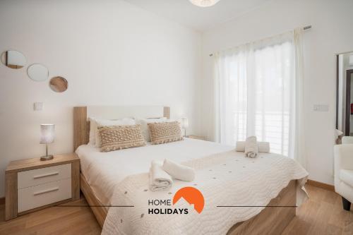 een witte slaapkamer met een groot bed met handdoeken erop bij #194 Dream Flat by Home Holidays in Vale de Pedras