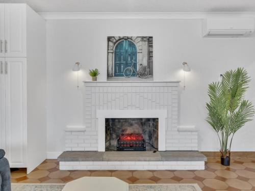 a living room with a white fireplace with a window at Parkside Flat - Seacliff Beach Suites in Leamington