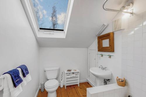 a bathroom with a toilet and a sink and a window at Linden Tree Carriage House in Newburyport