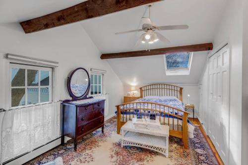 a bedroom with a bed and a mirror and a ceiling fan at Linden Tree Carriage House in Newburyport