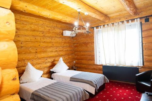 Habitación con 2 camas en una cabaña de madera en Mountain Lake JBS, en Focşani