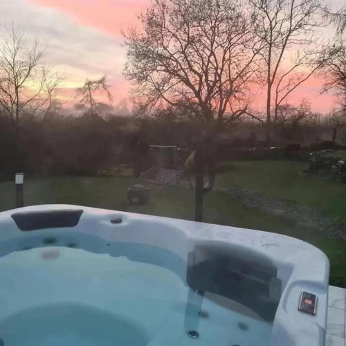 a bath tub with a view of a yard at Mill View Cottage at Pheasant Lane in Ráistín