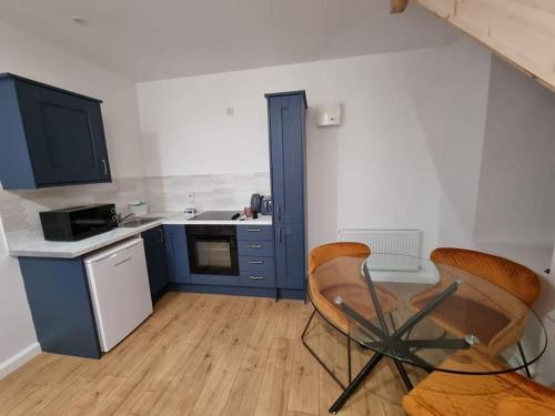 a kitchen with blue cabinets and a table and chairs at Mill View Cottage at Pheasant Lane in Ráistín