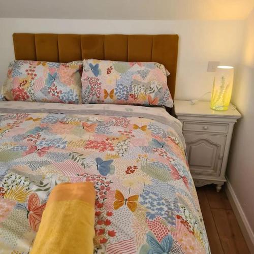 a bed with a comforter with butterflies on it at Mill View Cottage at Pheasant Lane in Ráistín