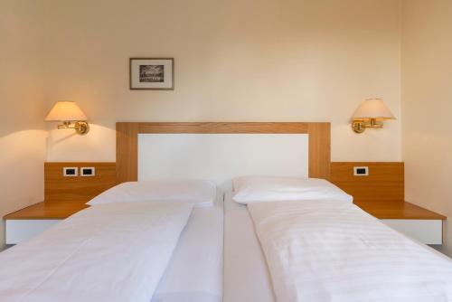 duas camas num quarto com duas lâmpadas na parede em Weingarten Terlan - Rooms & Breakfast em Terlano