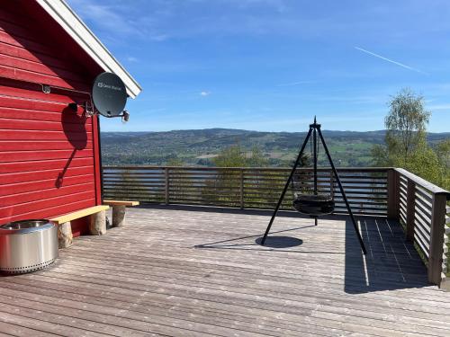 een veranda met een schommel aan de zijkant van een rood gebouw bij All inclusive villa in Lillehammer