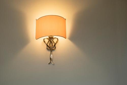 a lamp on a wall with an orange shade at Weingarten Terlan - Rooms & Breakfast in Terlano
