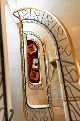 a woman walking down a spiral staircase at Weingarten Terlan - Rooms & Breakfast in Terlano
