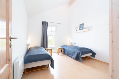 - une chambre avec 2 lits et une fenêtre dans l'établissement Strandpark Sierksdorf H087, à Sierksdorf