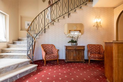 a room with two chairs and a staircase at Weingarten Terlan - Rooms & Breakfast in Terlano