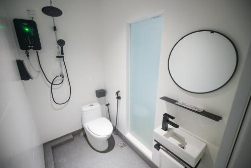 a bathroom with a white toilet and a mirror at Double H Boutique Hotel in Kuala Terengganu