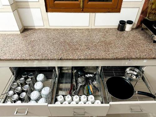 a kitchen drawer with pots and pans in it at Ajnara 2 in Varanasi