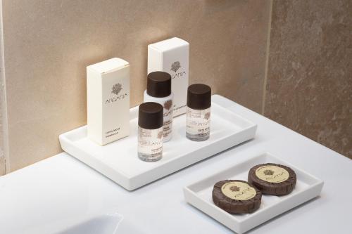 a bathroom sink with two bottles of soap and cookies at Amazing Piazza Venezia Suites in Rome