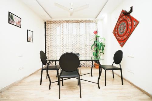 ムンバイにあるKAE Residencyのダイニングルーム(ガラステーブル、黒い椅子付)